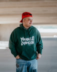 Model wearing unisex Young & Chosen Christian hoodie — cozy fleece with the reminder of their identity in Christ.