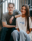 Faith-based "Be Truth & Light" graphic tee styled by female model next to male model wearing Transformed Christian shirt with scripture back print.