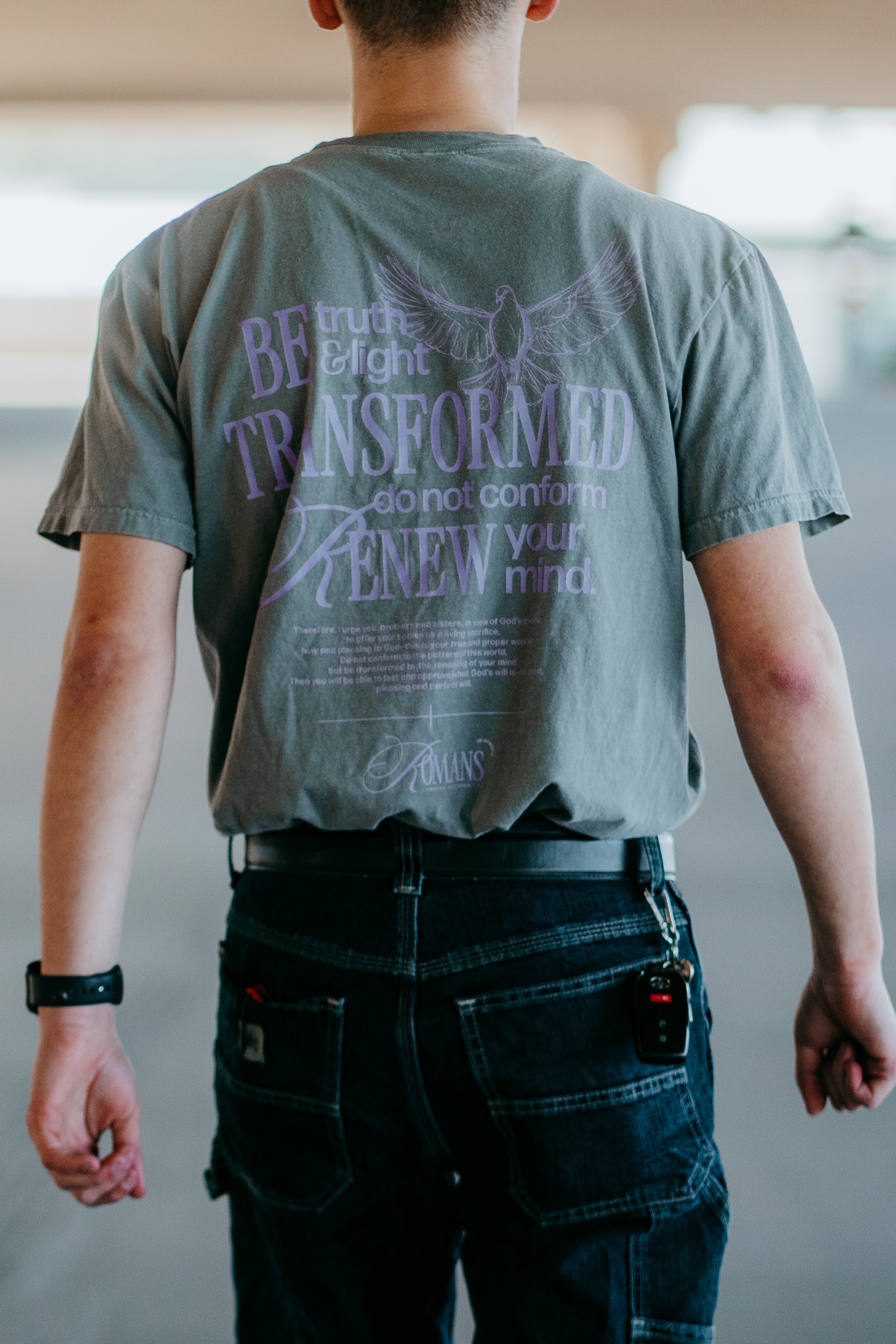 Christian streetwear "Be Truth & Light" t-shirt worn by male model displaying back graphic Transformed Romans 12:2 design.