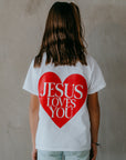 Faith-based kids’ t-shirt showing playful back design proclaiming Jesus Loves You to everyone they meet.